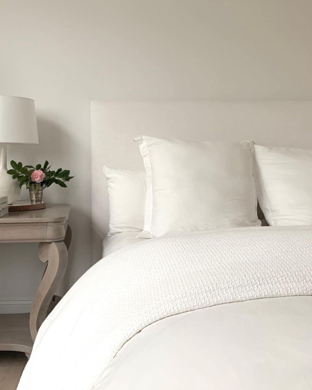 lit de type hôtel dans une chambre à coucher blanche