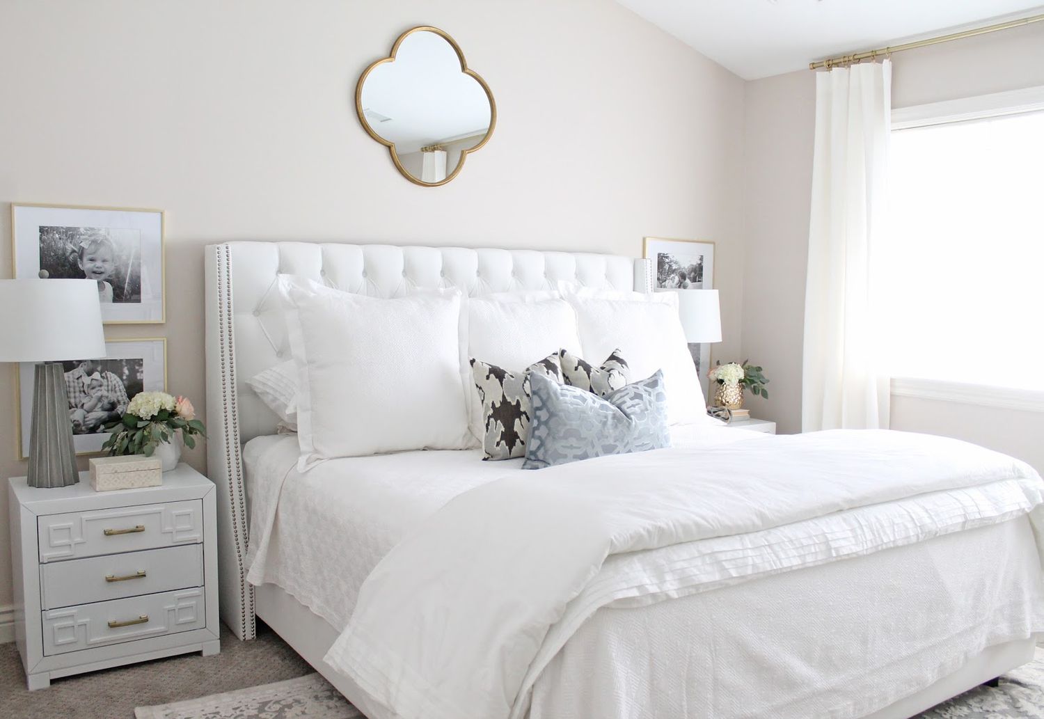 miroir en laiton au-dessus du lit dans une chambre à coucher blanche