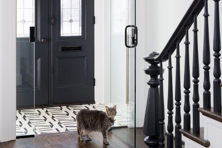 Portes vitrées et carrelage noir et blanc dans l'entrée d'une maison de ville