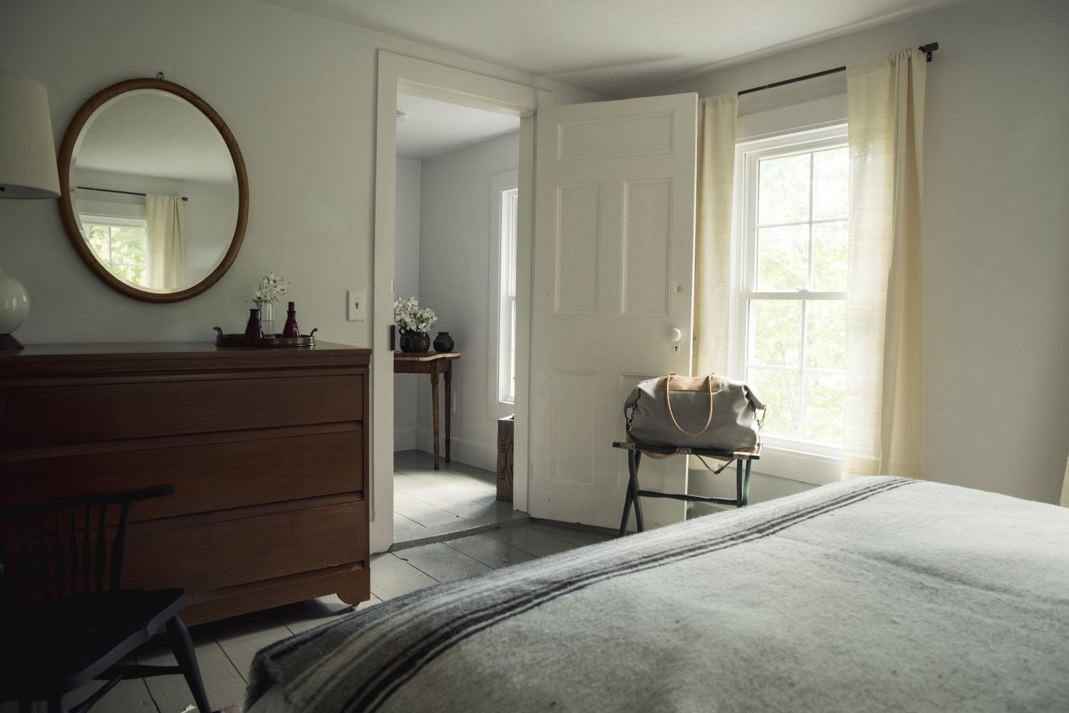chambre à coucher dans une maison de campagne avec un miroir face au lit