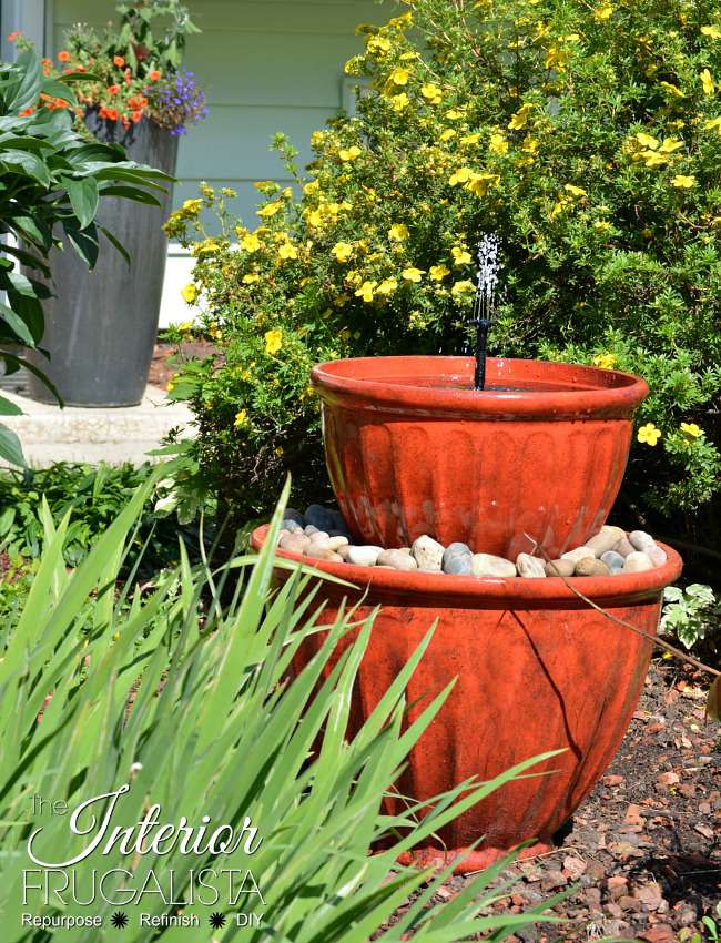 Une simple fontaine en gradins avec des pots de fleurs.