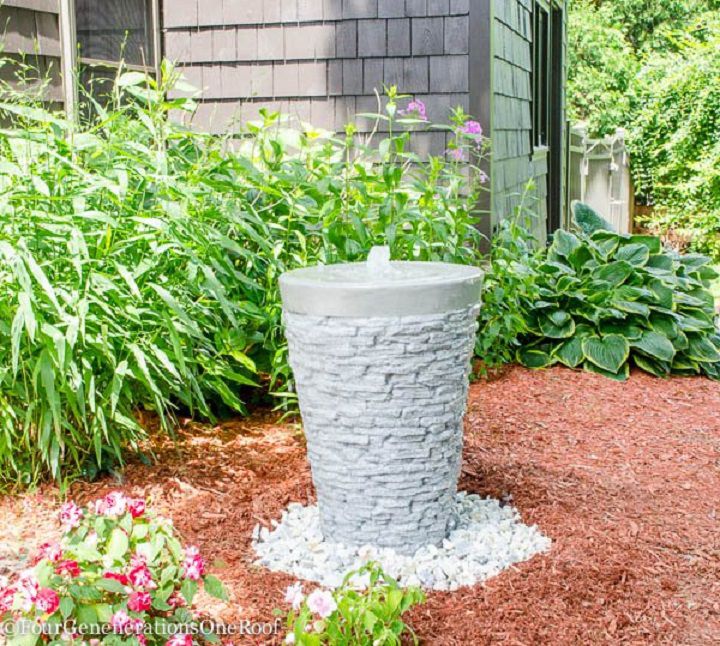 Une simple fontaine d'eau bouillonnante dans un jardin.
