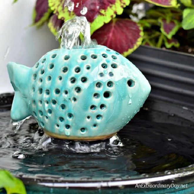 Un poisson bleu en céramique avec de l'eau qui en sort.