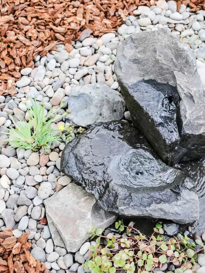 L'eau s'écoule d'une fontaine à eau en pierre bricolée.