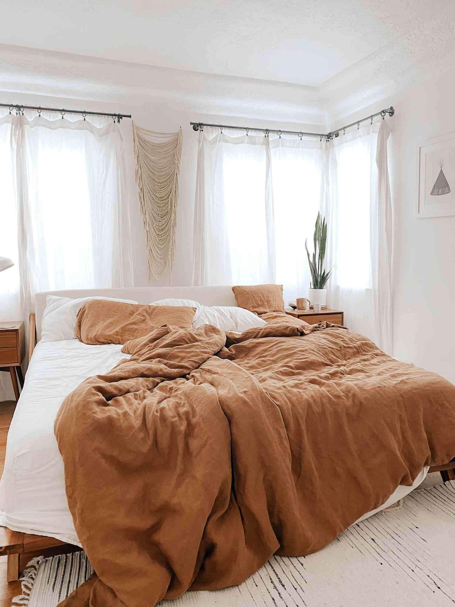 Lit entouré de fenêtres et de draperies aérées
