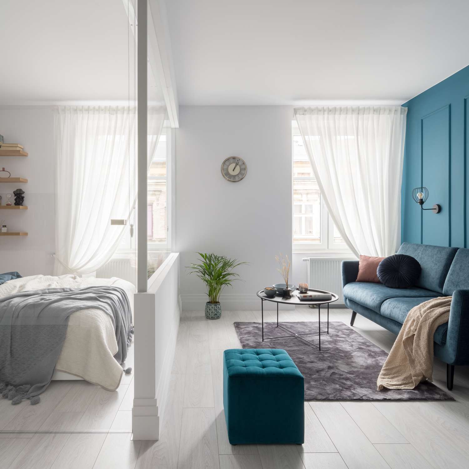 studio blanc et lumineux avec un demi-mur en guise de séparateur de pièce