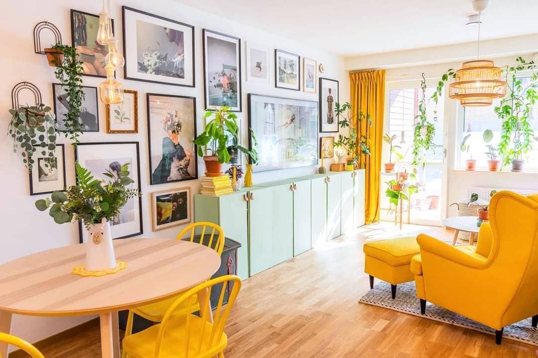Un salon lumineux avec des touches de jaune et beaucoup de plantes d'intérieur.