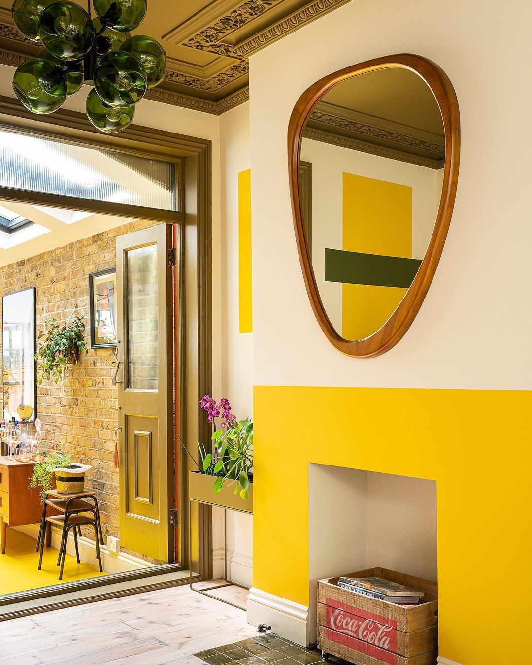 Un salon élégant et moderne avec une fausse cheminée jaune et des murs d'accent jaunes.