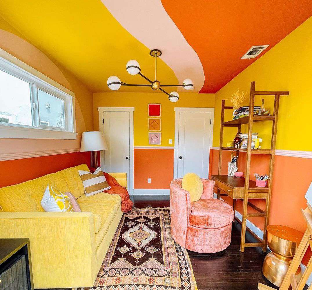 Un salon lumineux et audacieux avec des murs et des meubles jaunes associés à de l'orange et du rouge.