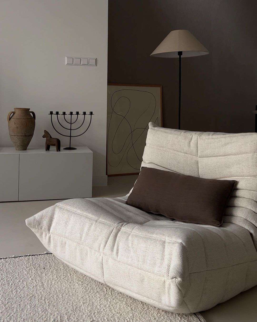 Fauteuil d'appoint blanc avec oreiller et lampe bruns