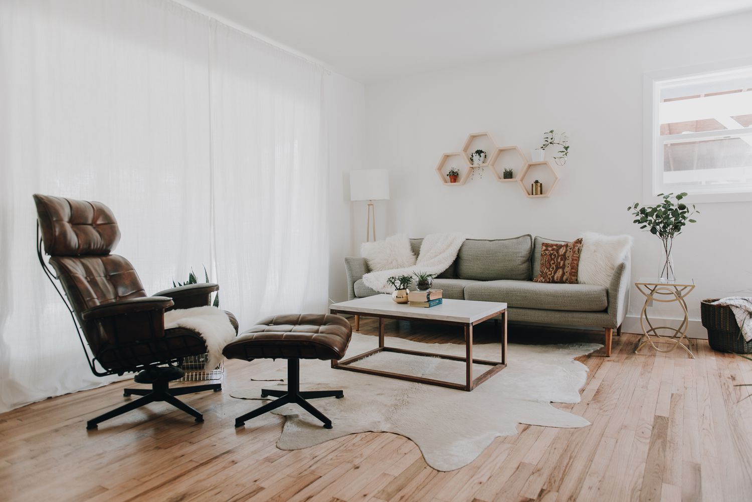 Salon ouvert et spacieux avec planchers en bois et tapis en peau de vache