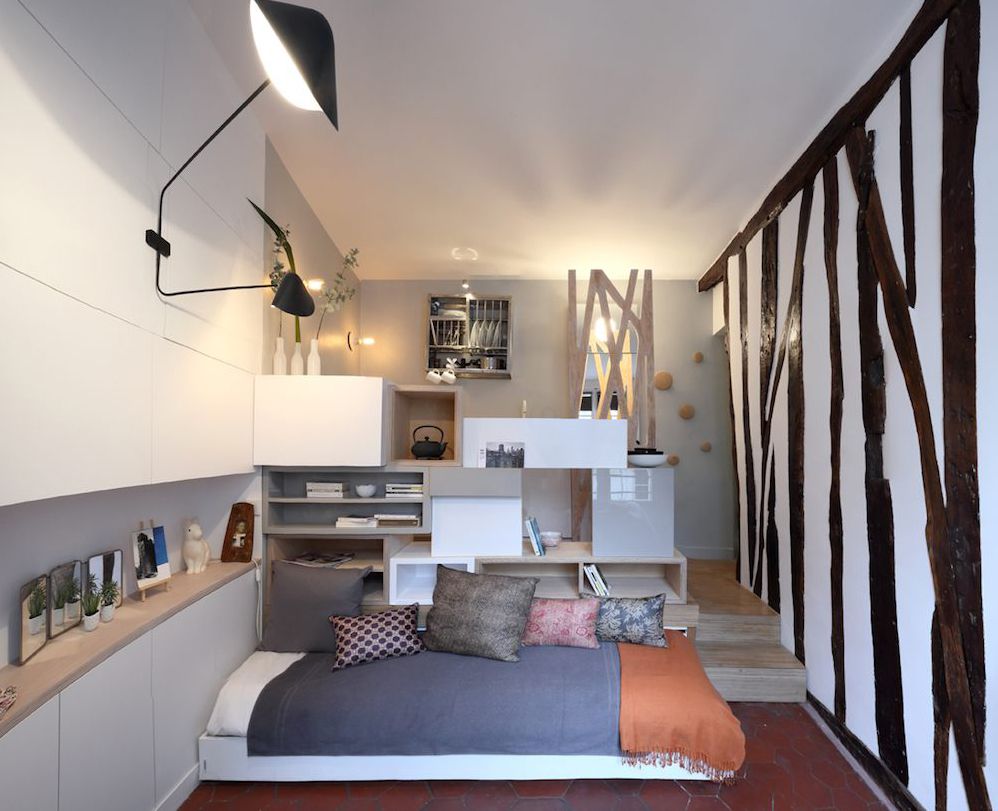 Studio avec lit gigogne et mur rayé noir et blanc.