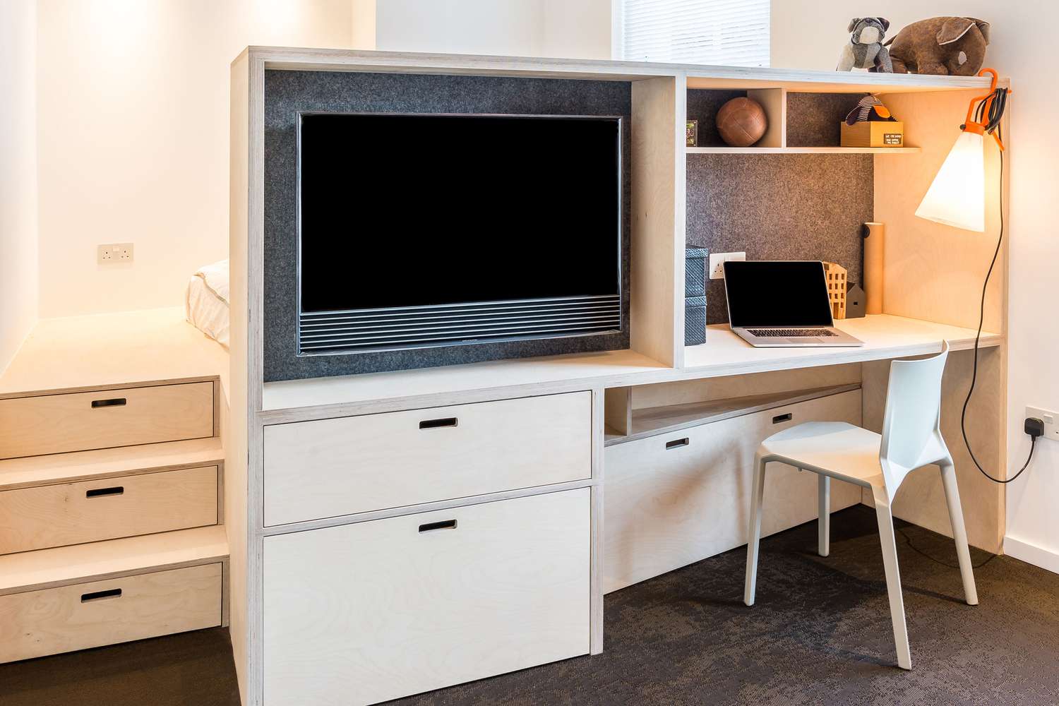 Bureau blanc avec espace intégré pour la télévision.