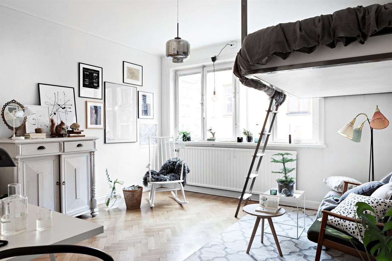 Studio avec lit en mezzanine et intérieur blanc.