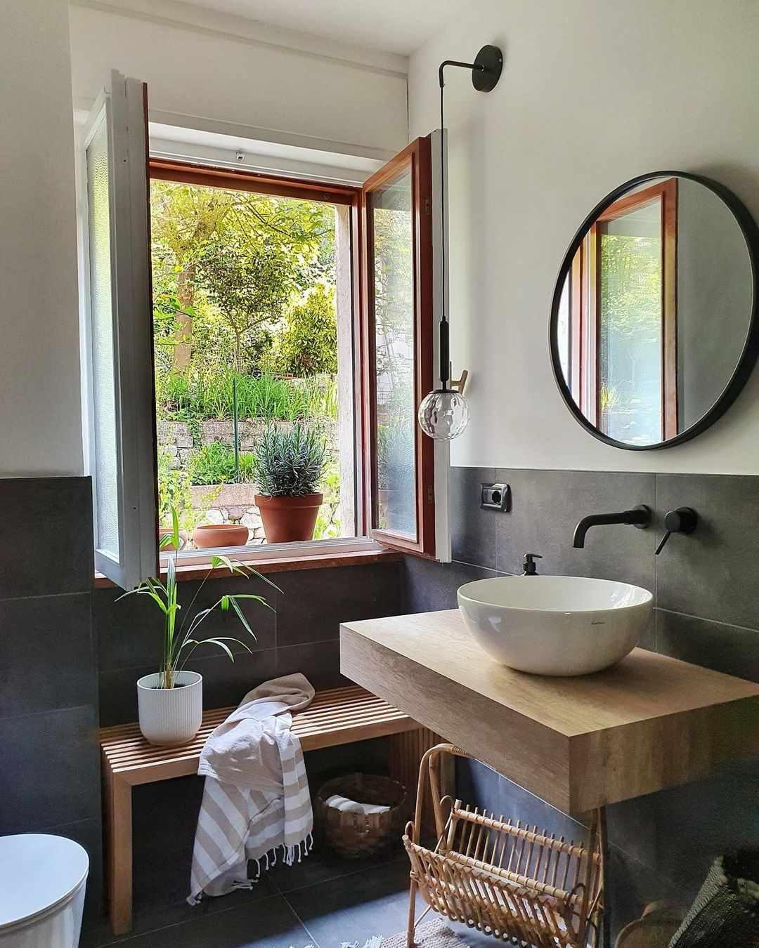 Un meuble-lavabo flottant en bois et un banc en bois dans une salle de bains