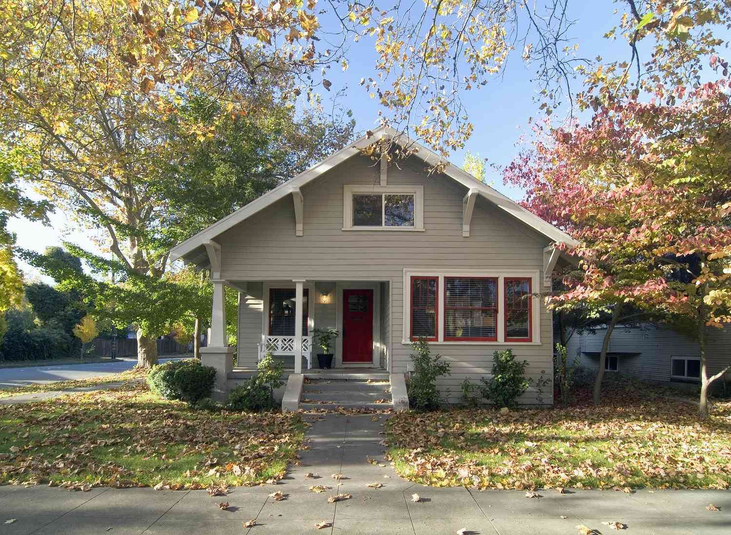 Façade extérieure d'un bungalow gris avec porte rouge