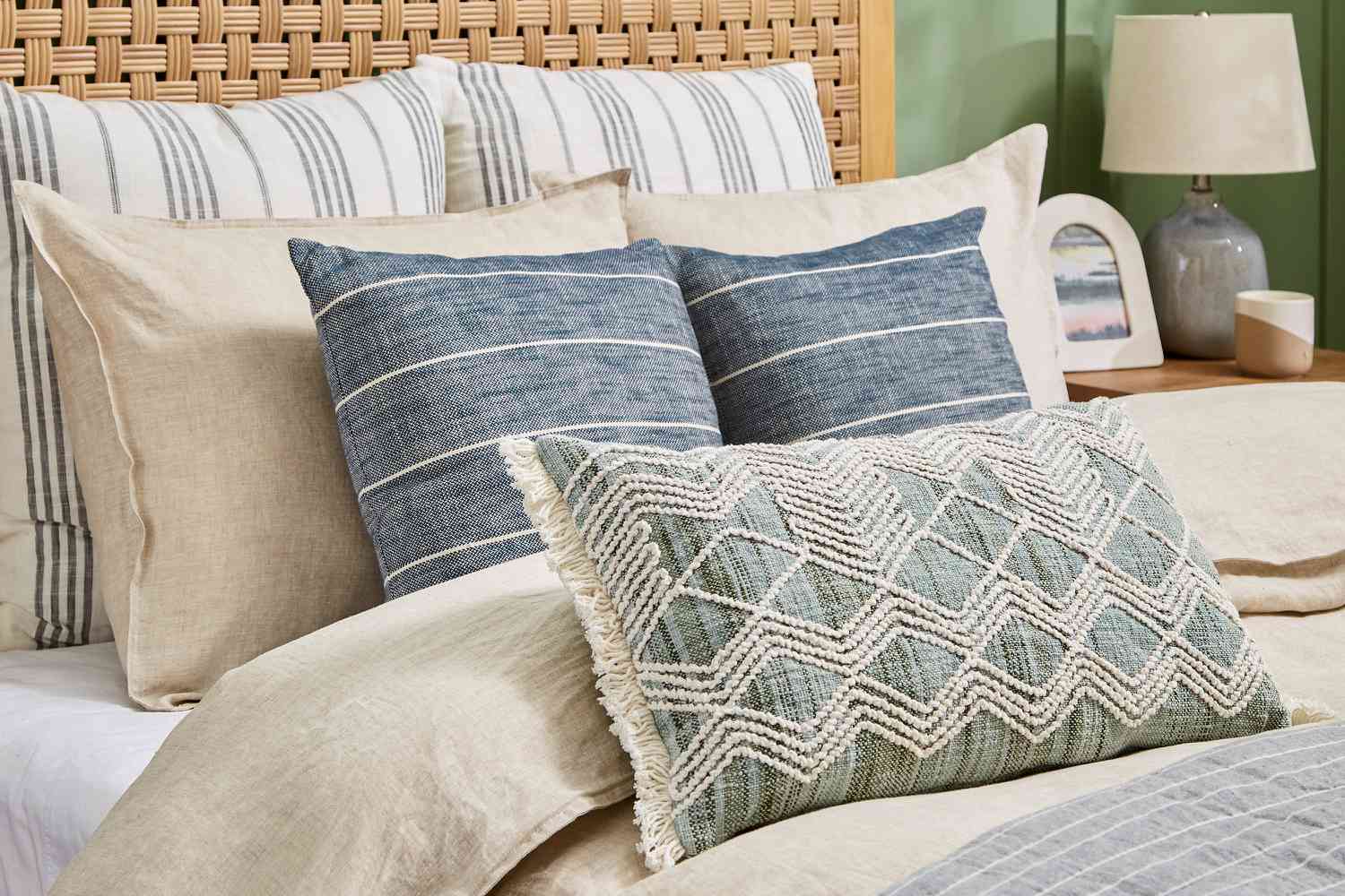 Gros plan sur des coussins placés sur un lit dans des couleurs discrètes.