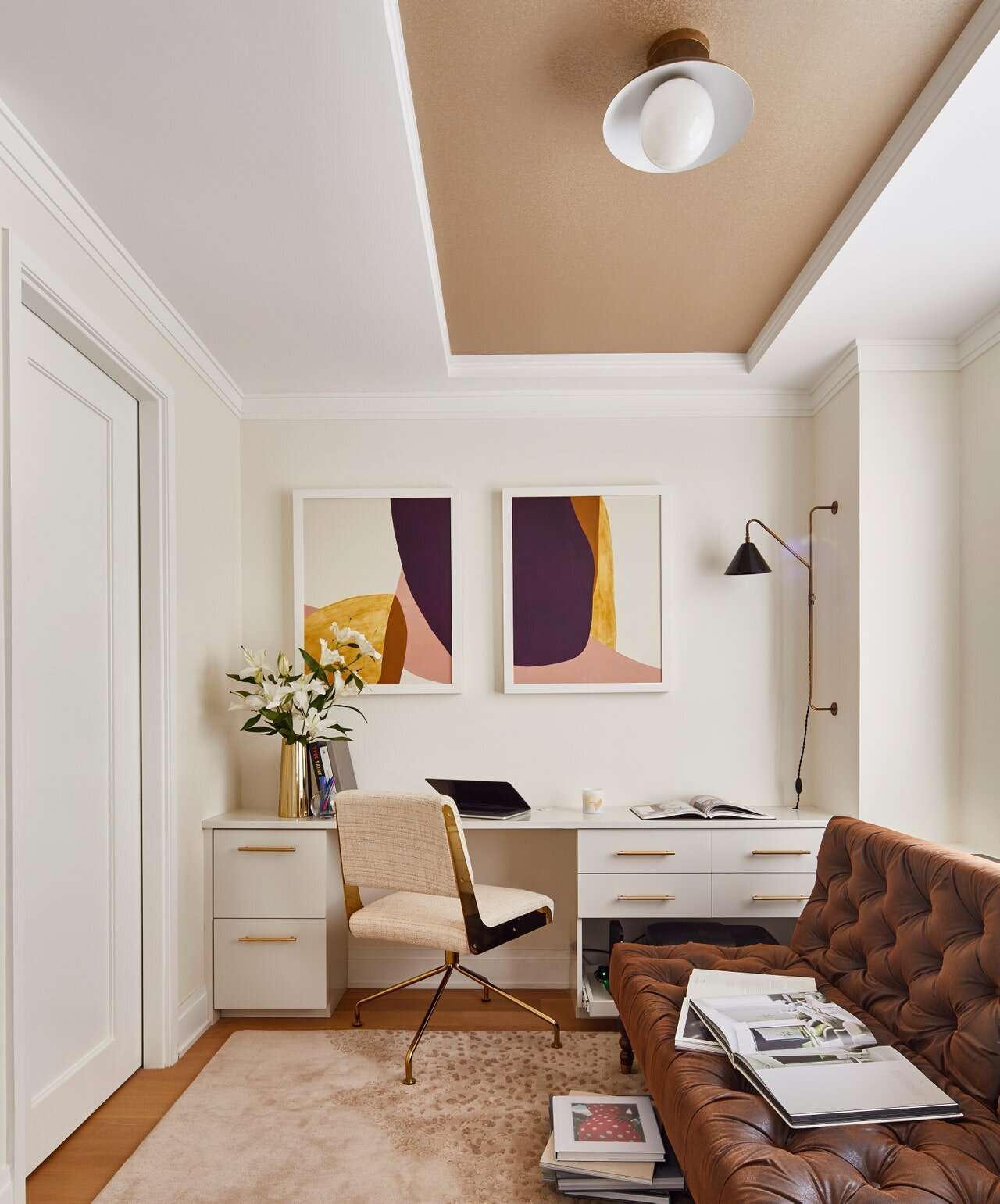 Applique murale noire au-dessus d'un bureau blanc dans un bureau à domicile moderne