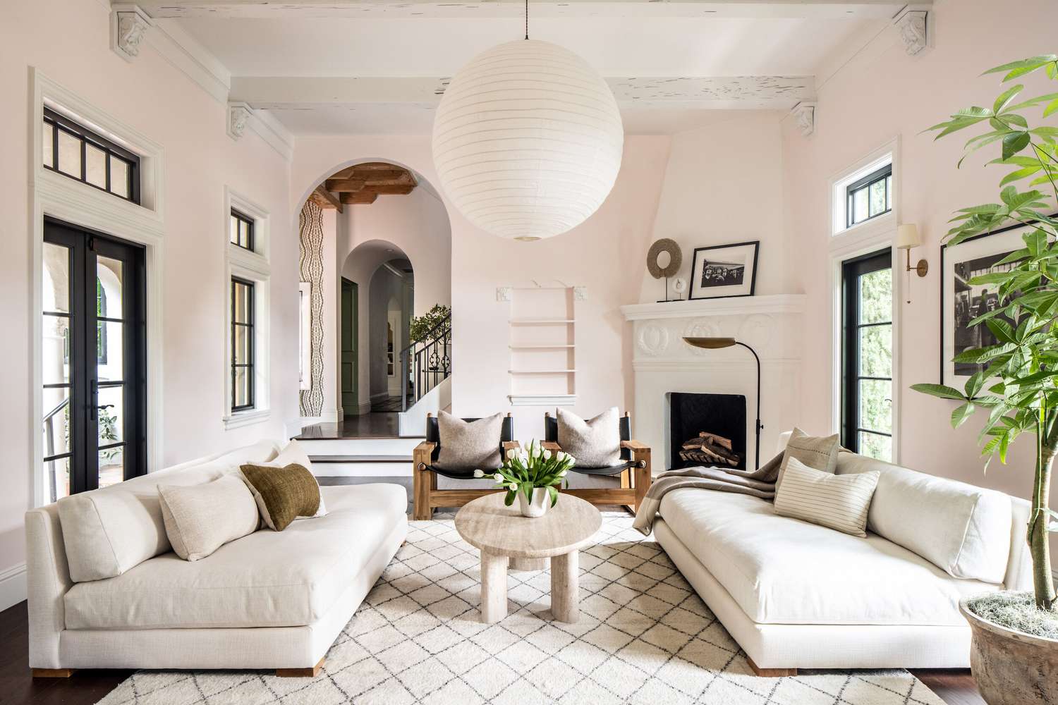 Un salon aux murs rose layette et aux accents blancs.