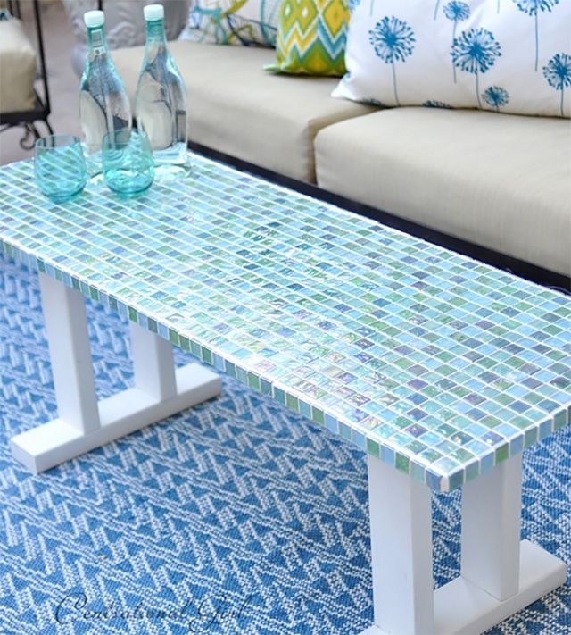 Une table basse d'extérieur recouverte de carreaux de verre bleus et verts.