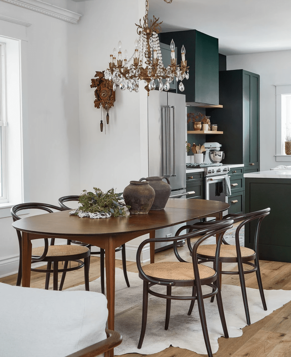 Une salle à manger remplie de meubles du milieu du siècle et d'un lustre doré orné.