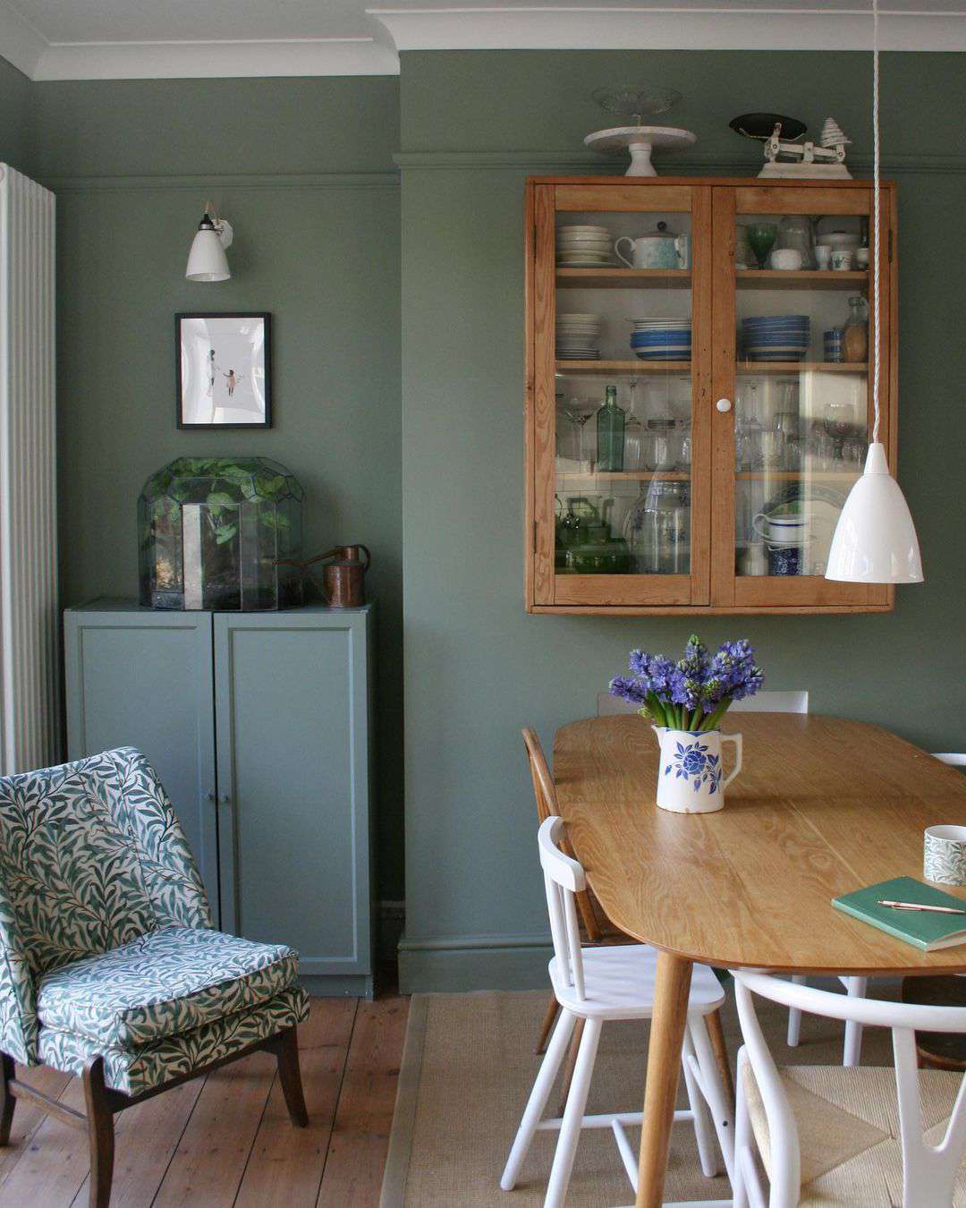 Salle à manger avec des murs d'un vert discret.