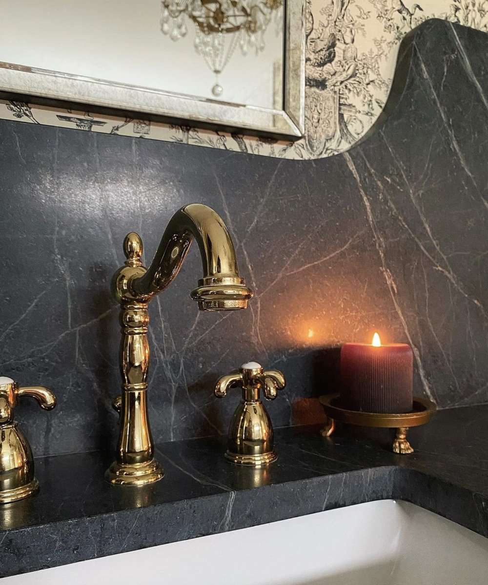 Salle de bain en marbre noir avec bougie rouge