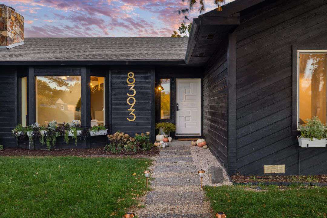 Maison noire avec des citrouilles près de la porte d'entrée