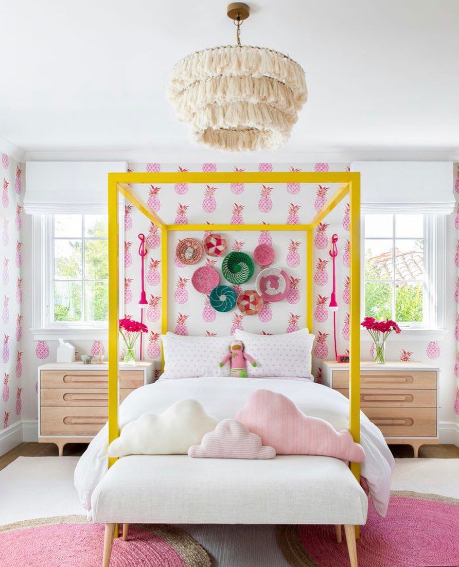 Une chambre d'adolescente colorée avec un papier peint ananas rose et blanc et un lit à baldaquin jaune fluo.