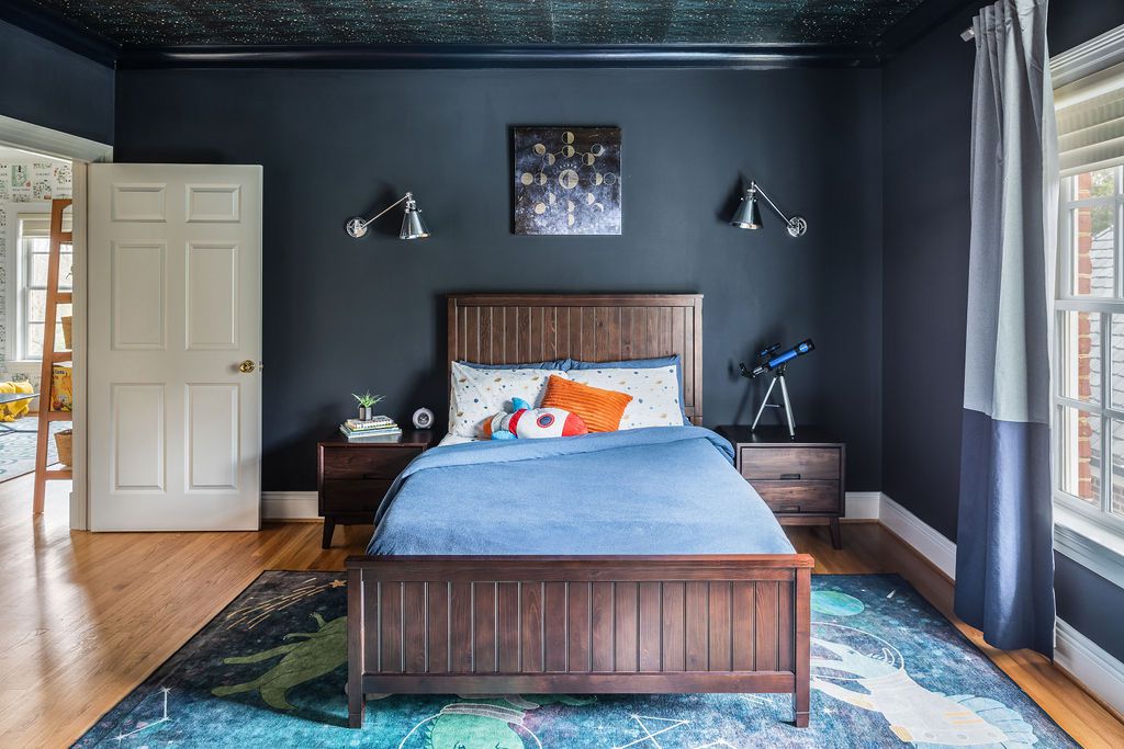 Chambre d'enfant avec peinture murale bleu foncé.