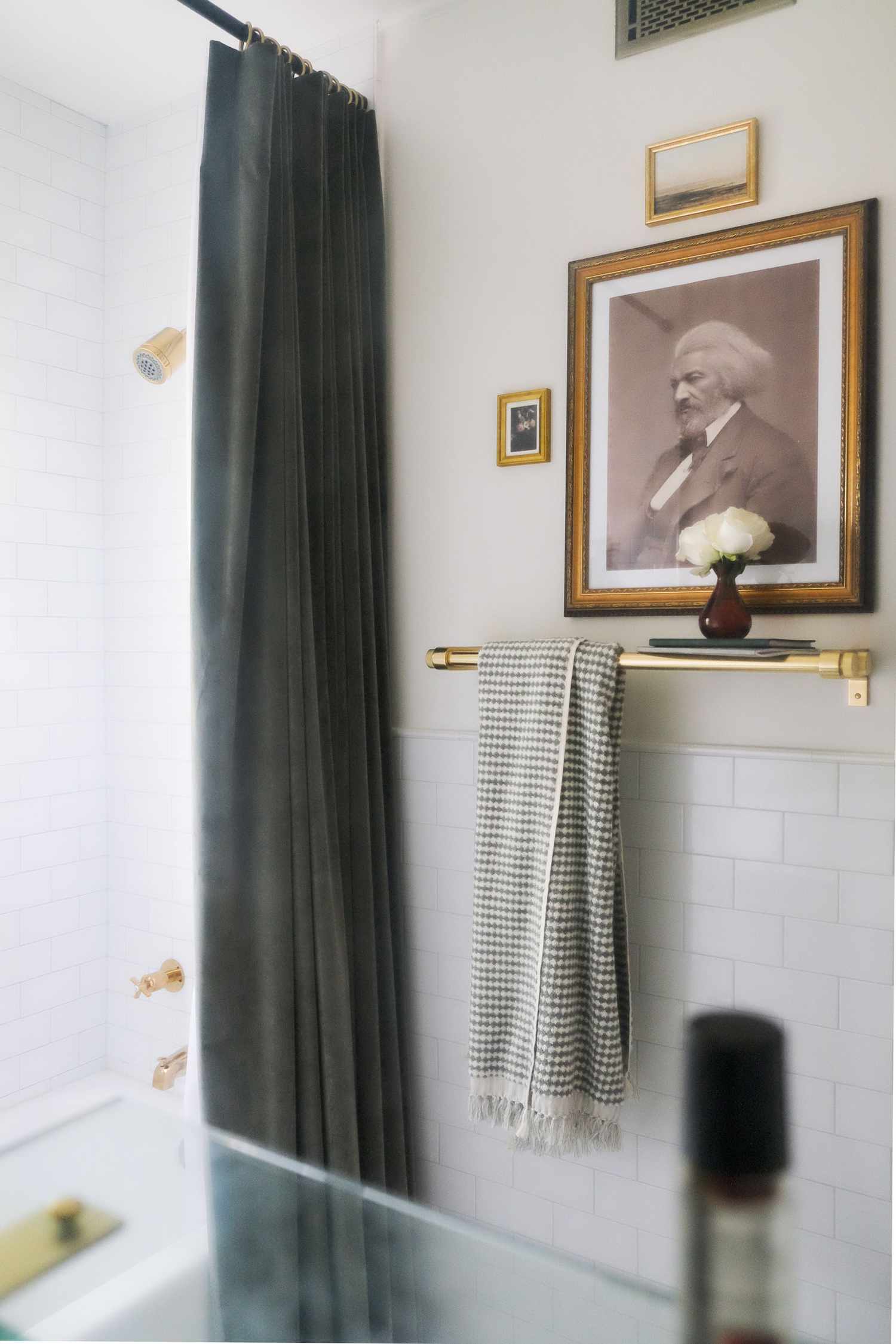 Une image de Frederick Douglass est présentée en noir, gris, blanc et beige pour célébrer l'héritage afro-américain dans cette petite salle de bains.