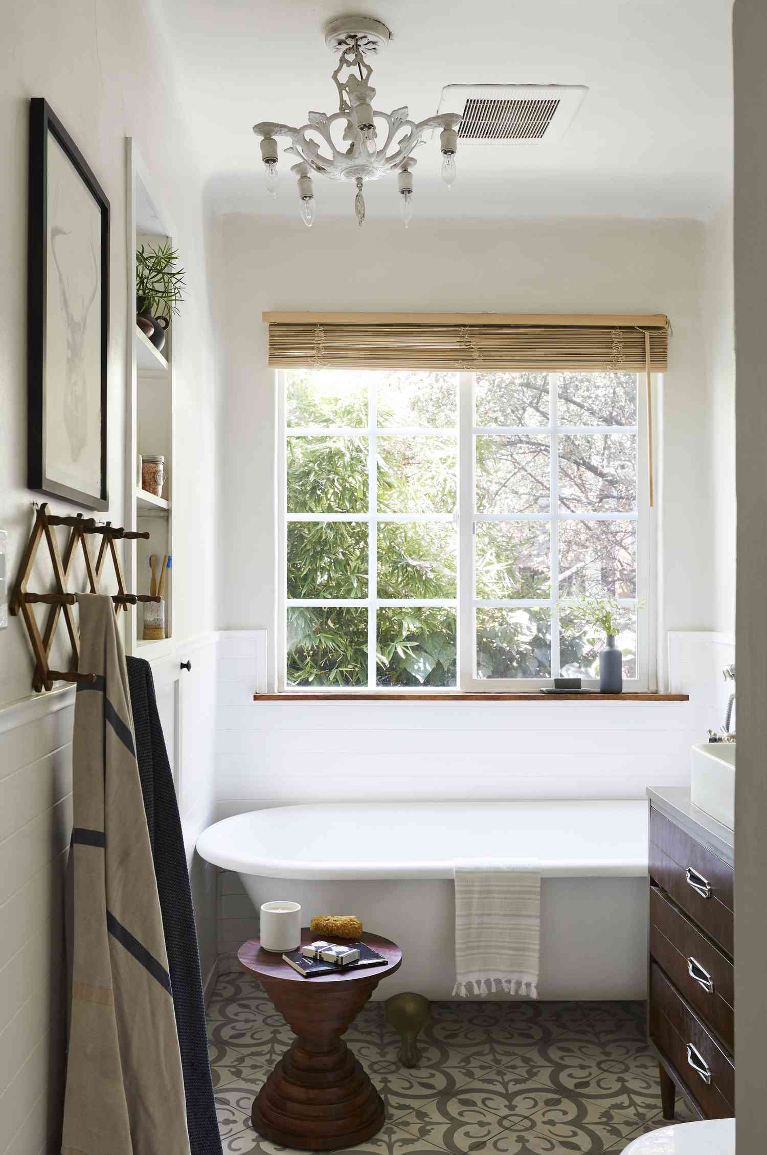 Une salle de bain blanche reçoit une touche de beige grâce à un rideau de fenêtre beige.