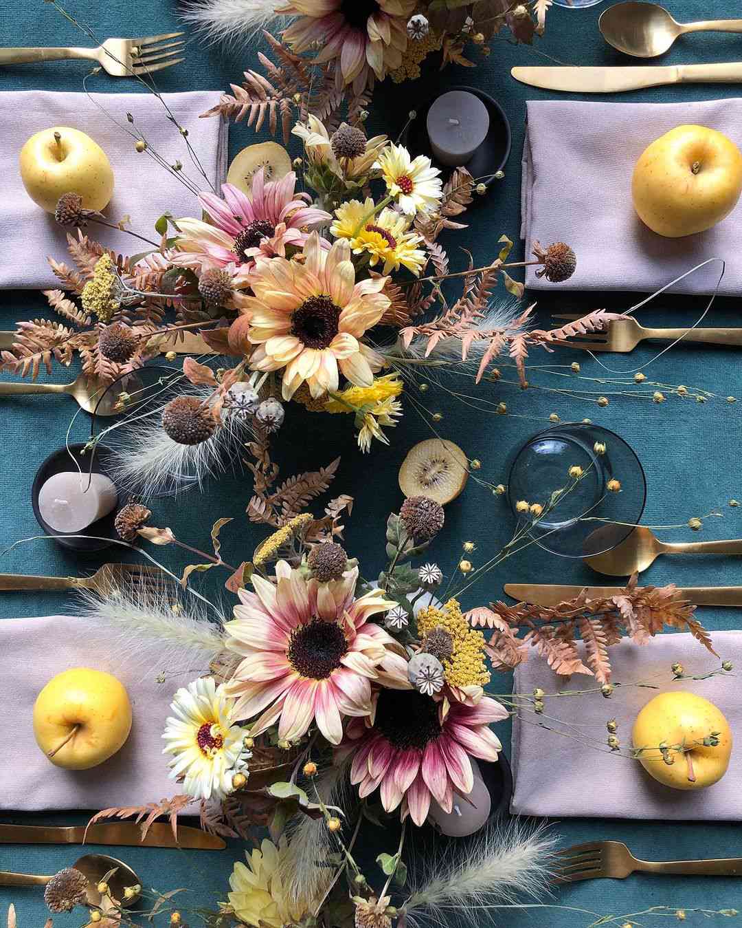 Table avec couverts, pommes et fleurs en or