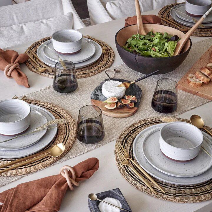 Paysage de table avec des assiettes grises et un chemin de table beige