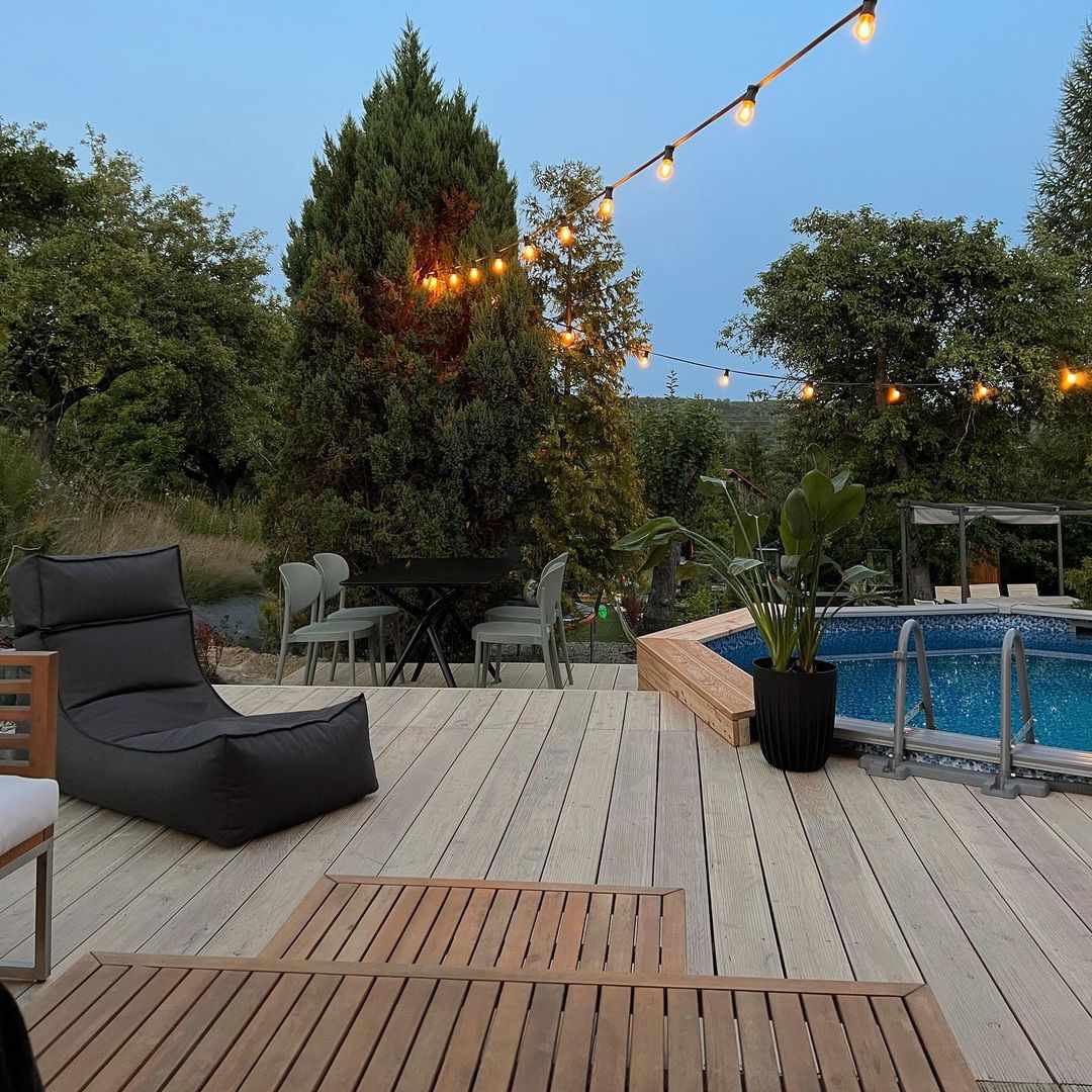 Une arrière-cour avec une piscine et des guirlandes lumineuses
