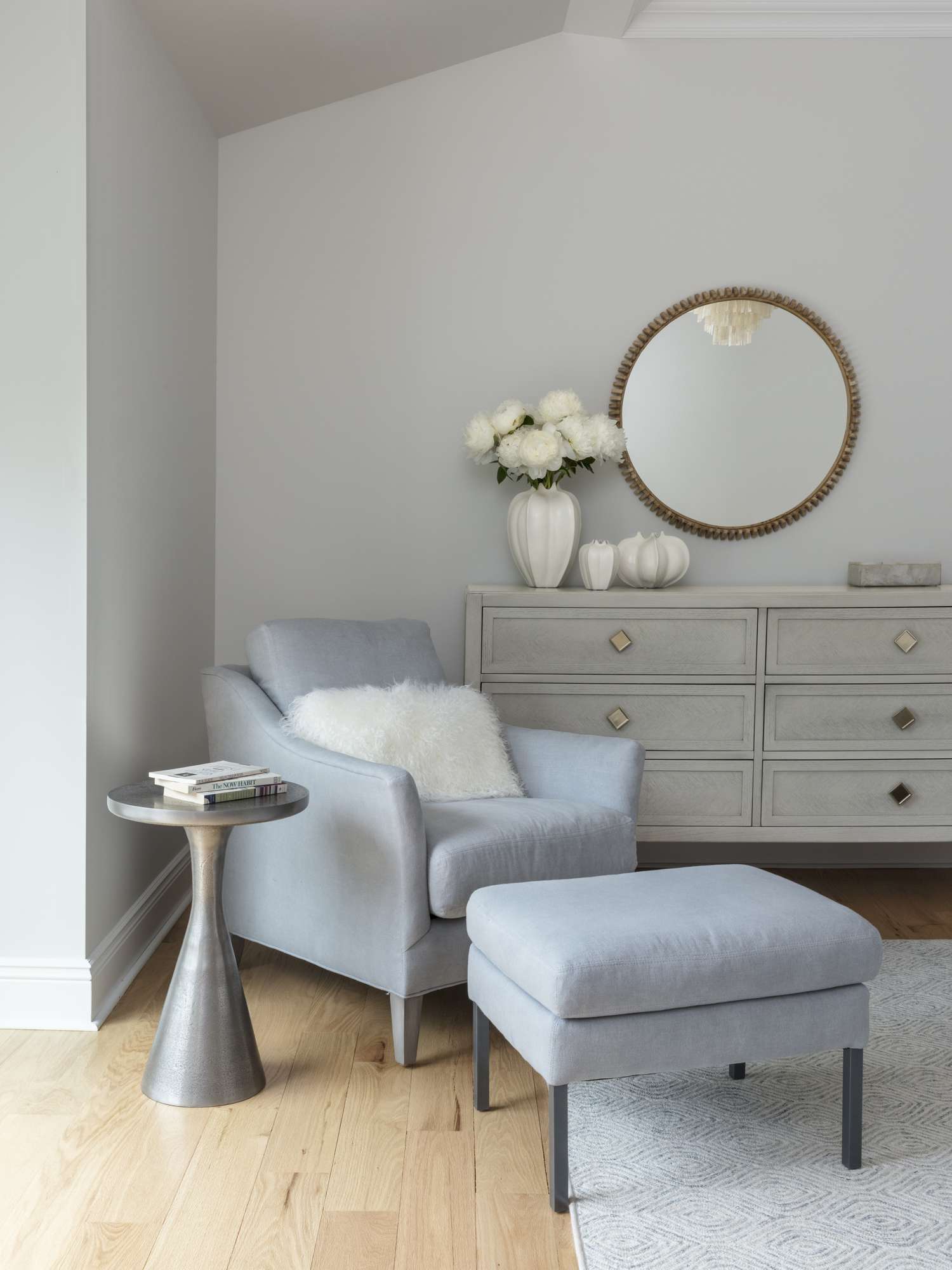 Un fauteuil bleu cristal est recouvert d'un coussin blanc moelleux.