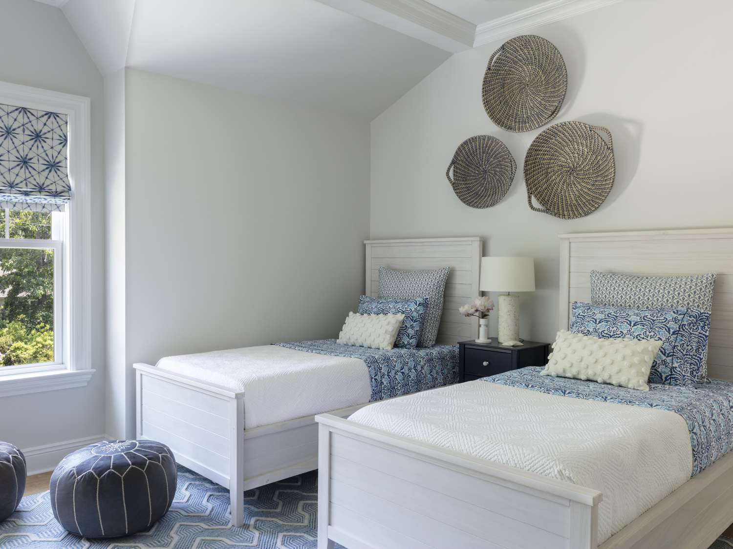 Les lits jumeaux sont équipés de draps et d'oreillers à motifs blancs et bleus.