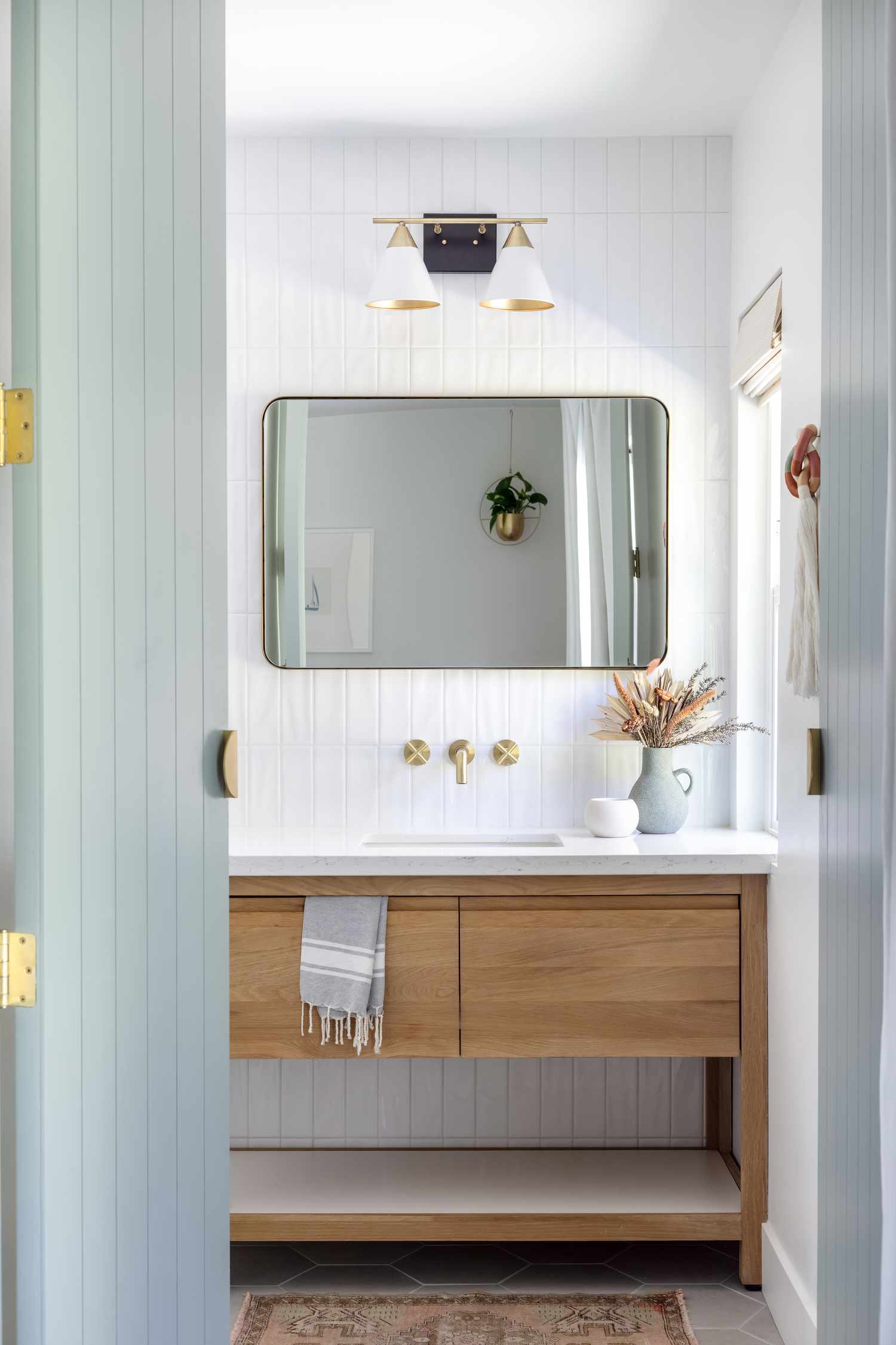 Une salle de bain blanche avec des portes grises et des murs en shiplap