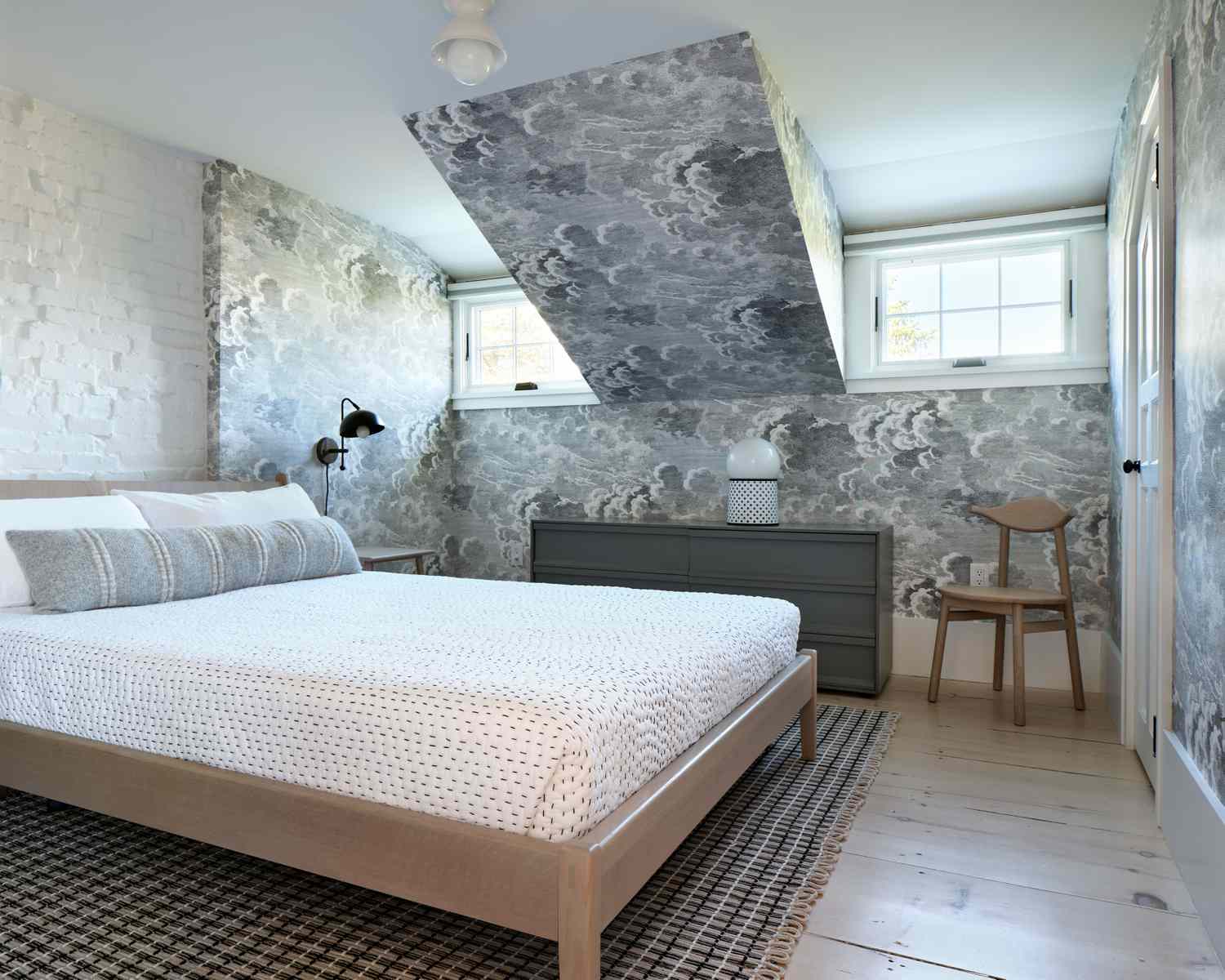 Le papier peint d'une chambre à coucher est couvert de nuages orageux. 
