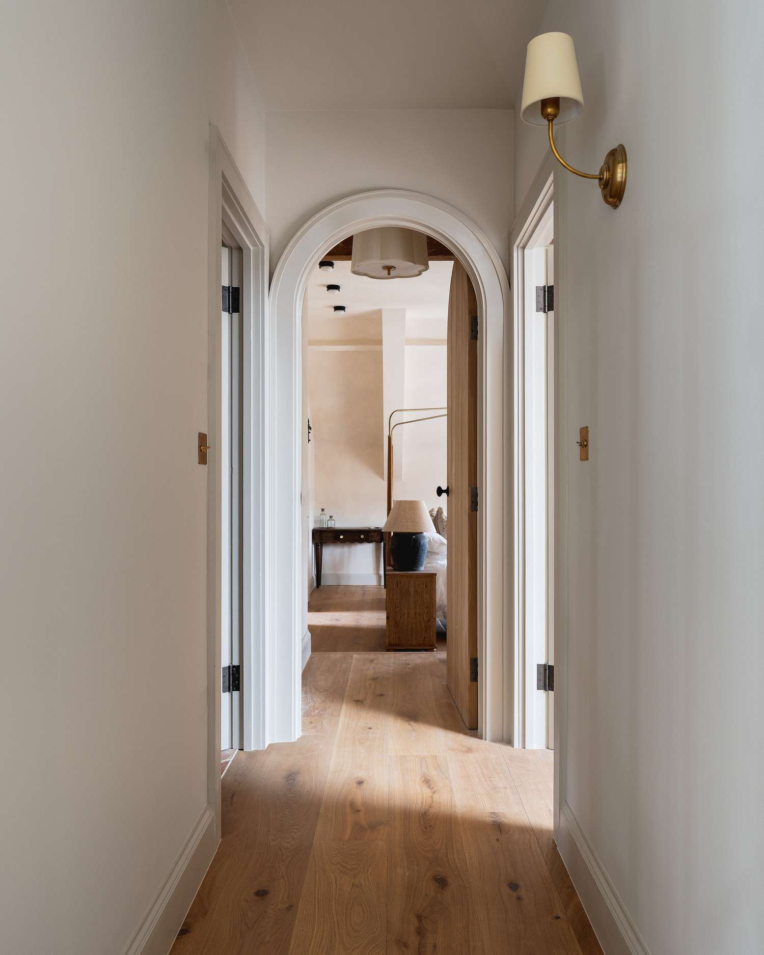 Couloir avec une applique murale en laiton avec un abat-jour blanc