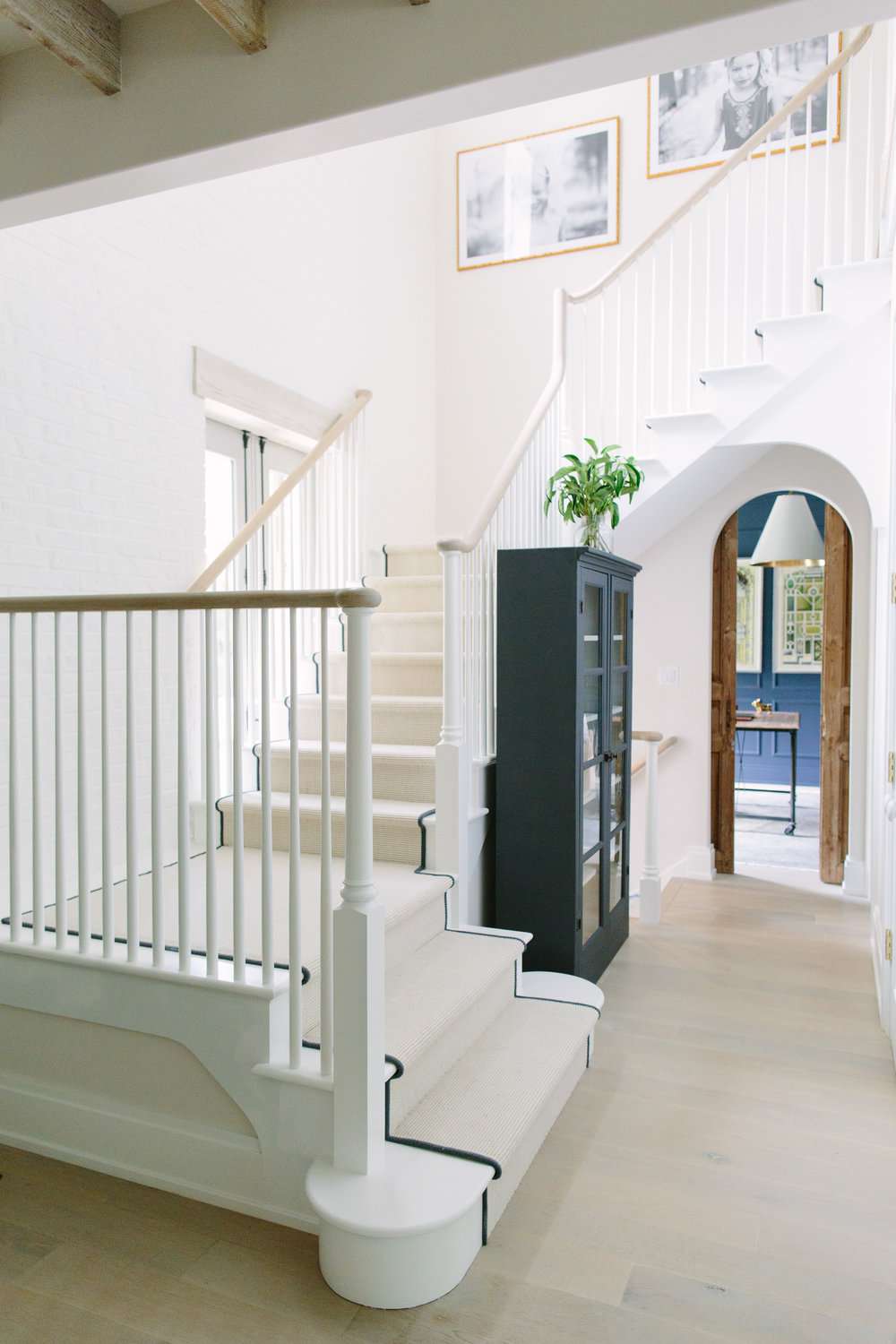 Grand meuble noir dans un couloir étroit près d'un escalier