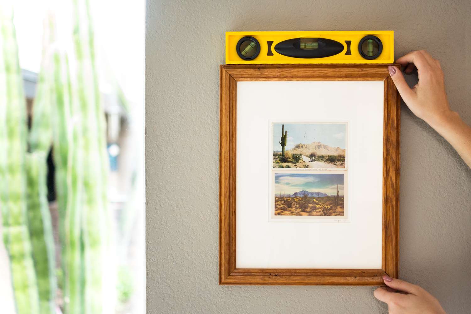 Cadre photo placé sur le mur avec un niveau jaune sur le dessus