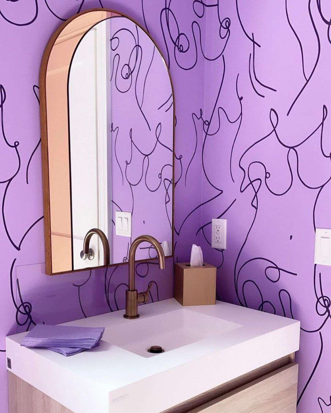 Salle de bains avec un papier peint violet et noir.