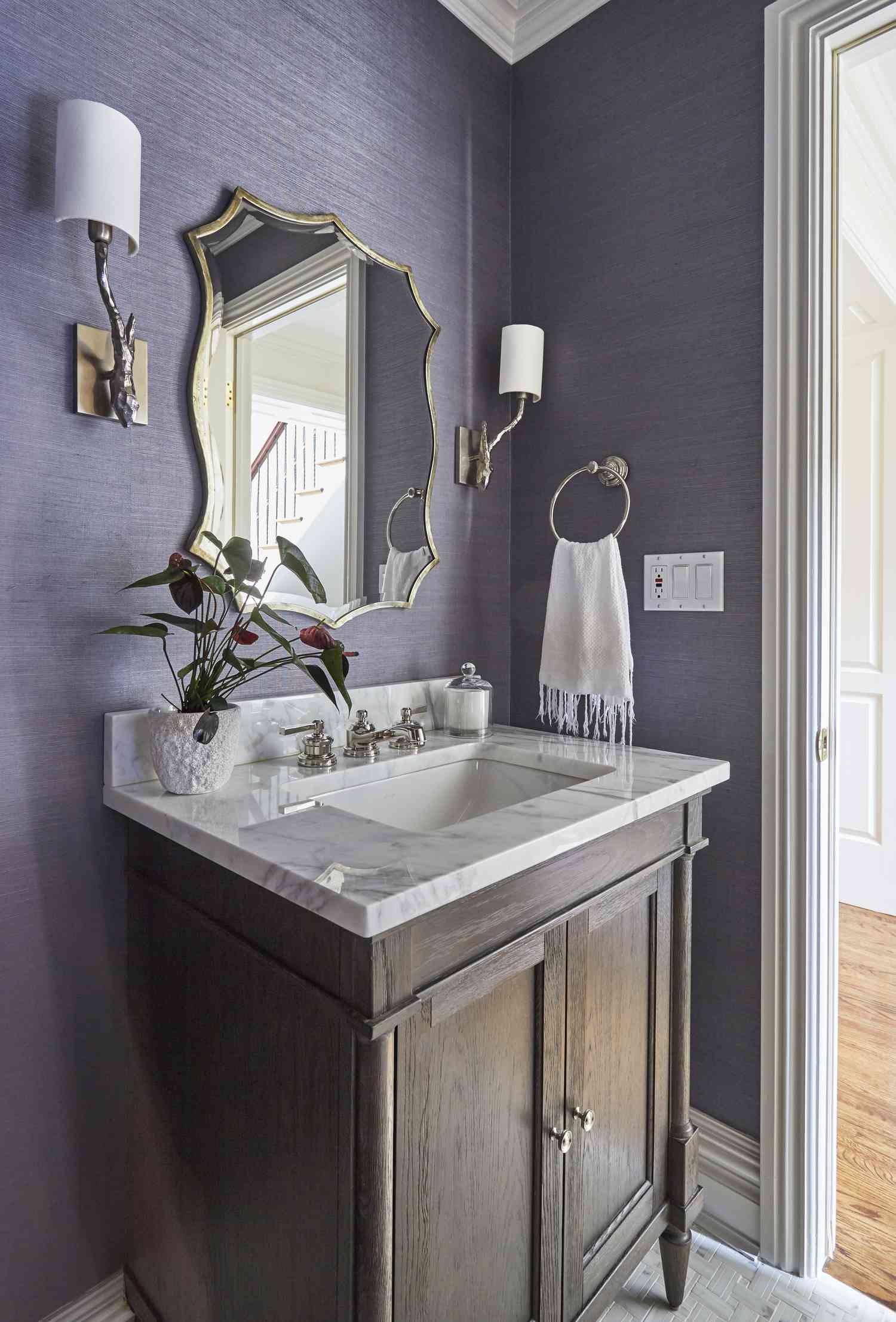 Salle de bains avec papier peint texturé violet.