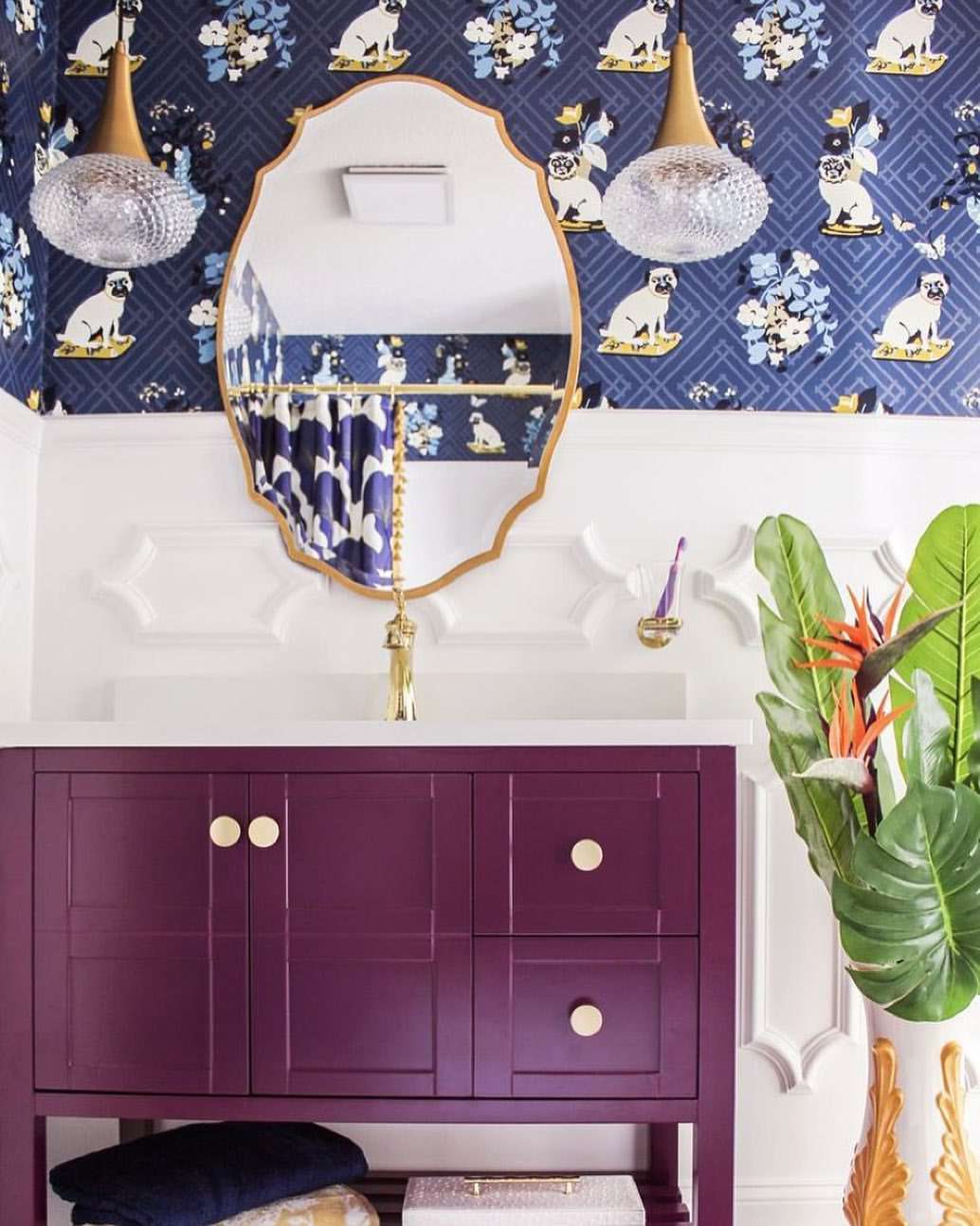 Salle de bains avec panneaux muraux ornés et meuble-lavabo violet.