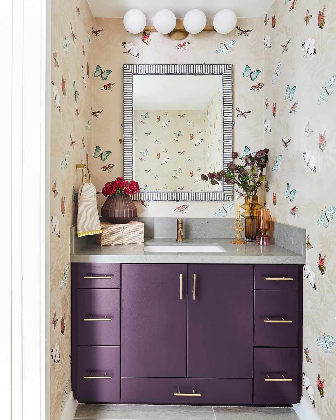 Petite salle d'eau avec meuble-lavabo violet foncé.