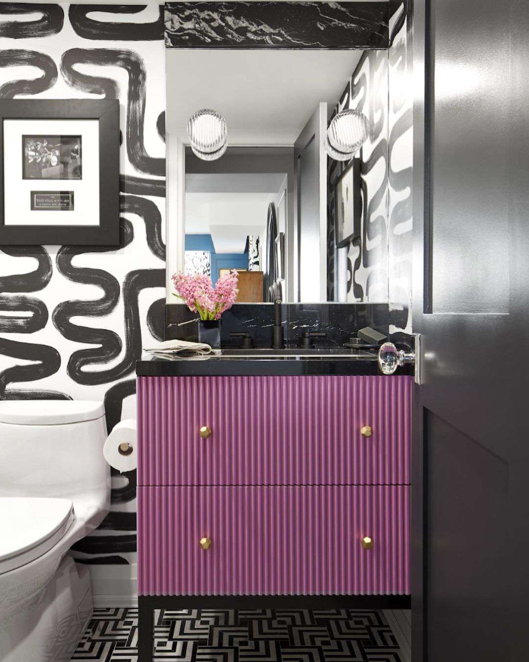 Salle de bain noire et blanche avec meuble-lavabo violet.