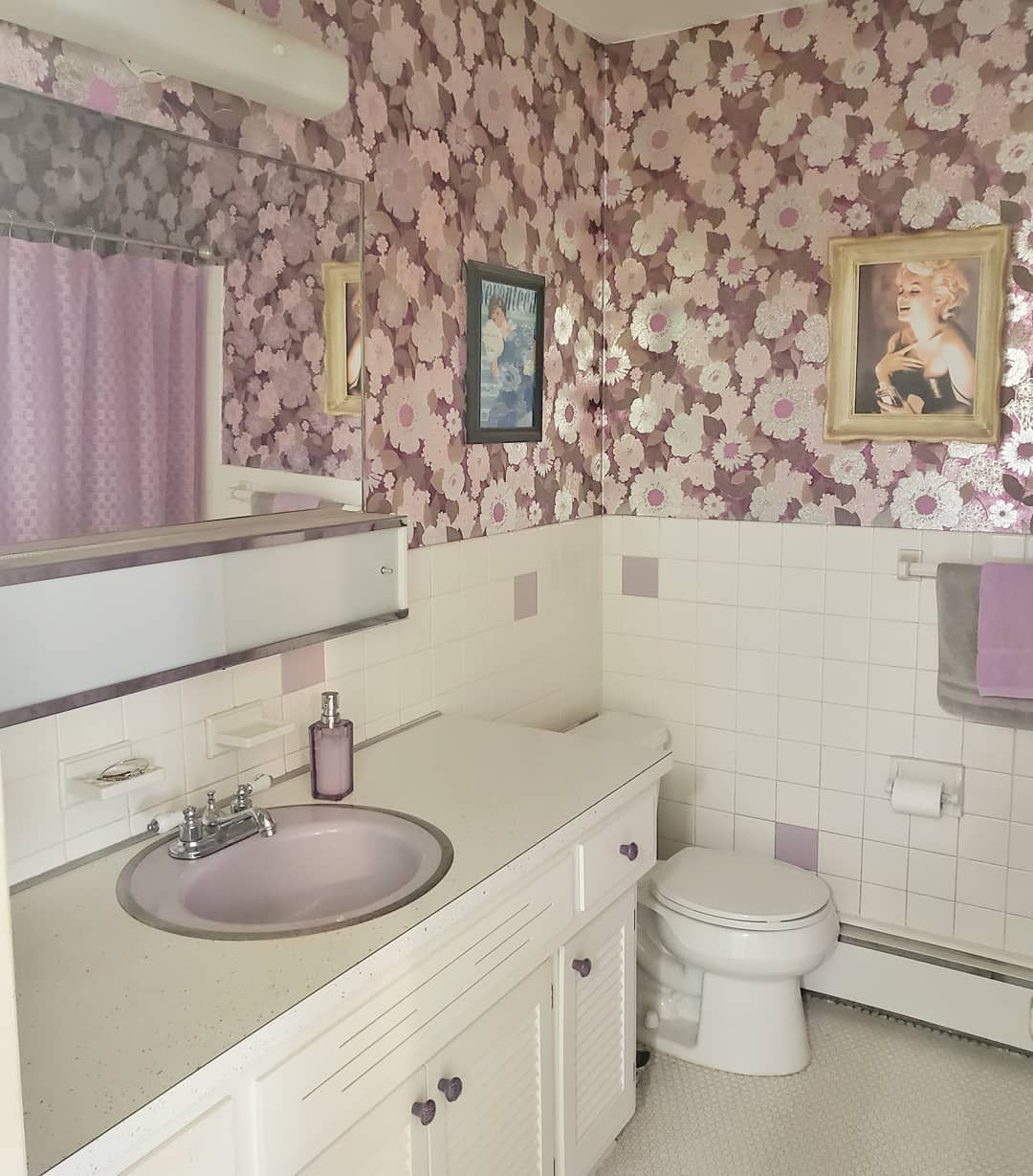 Salle de bains avec papier peint floral violet.