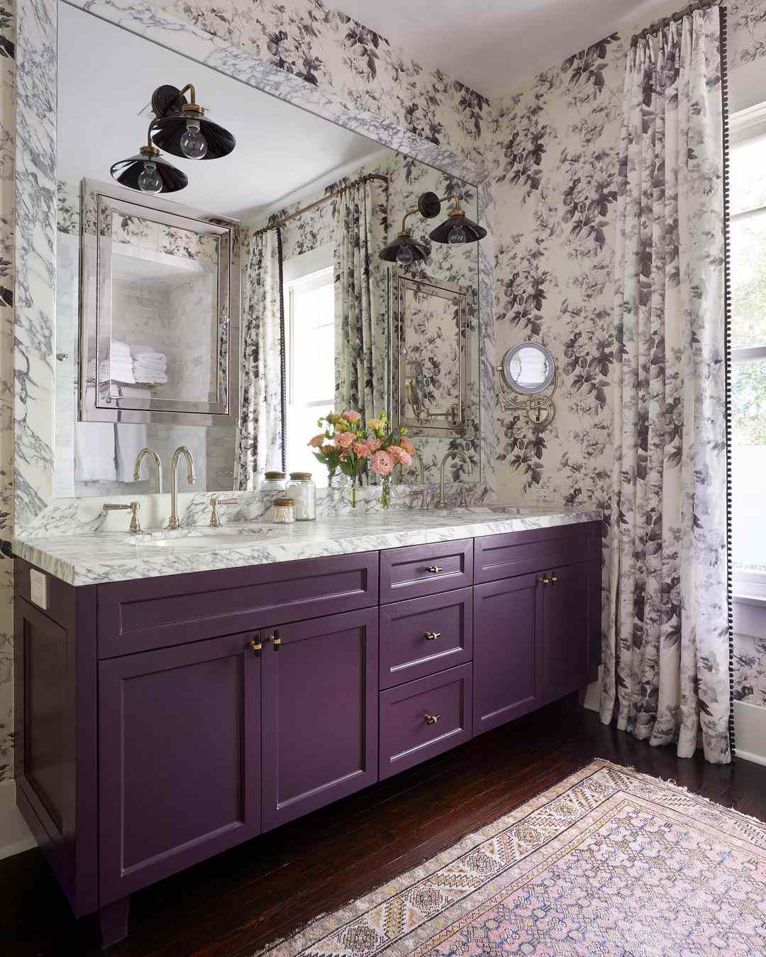 Salle de bains avec meuble-lavabo violet, papier peint et rideaux assortis.