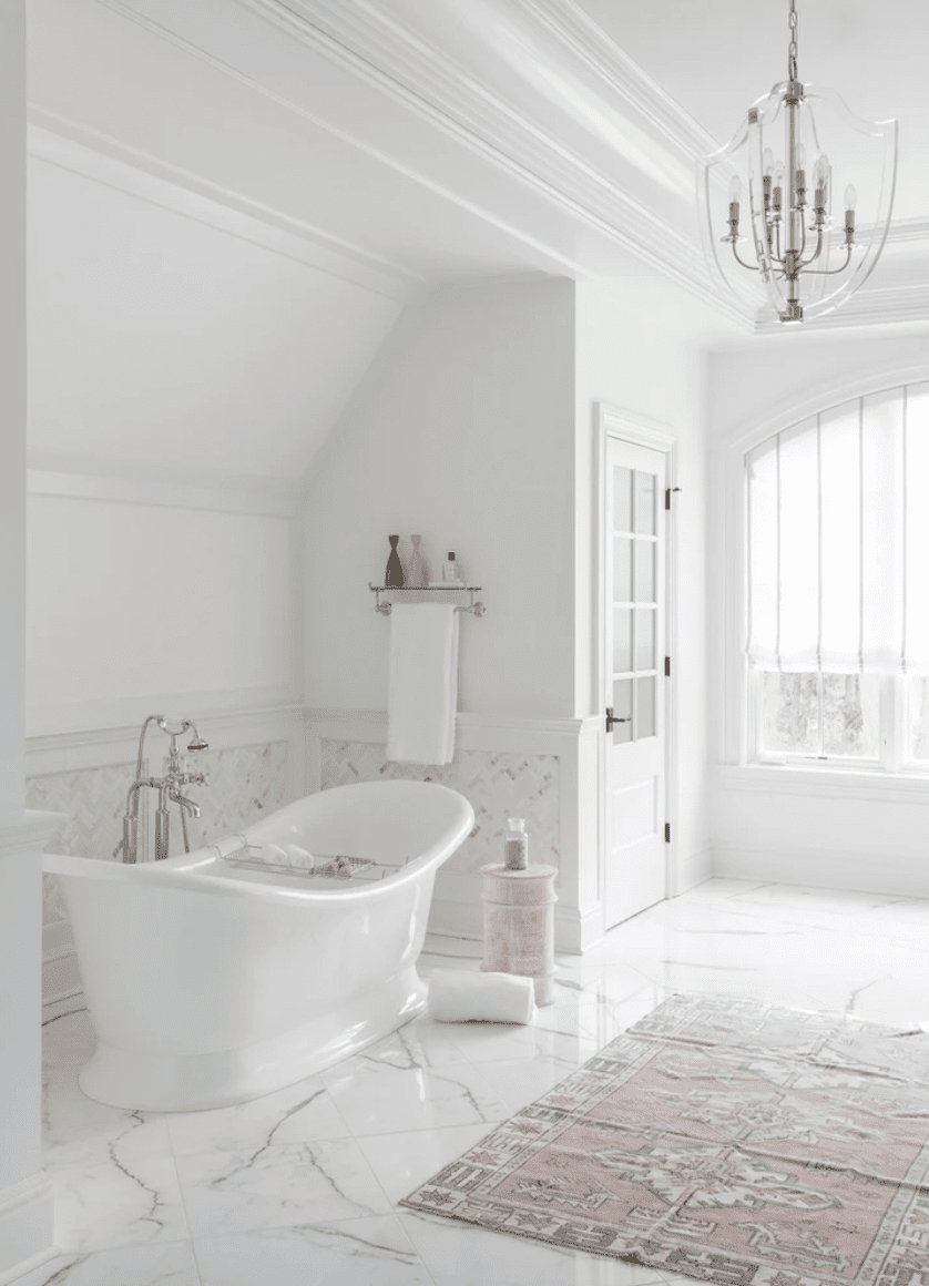 Salle de bain en marbre clair et blanc avec baignoire